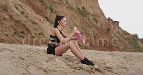 在海边的海边运动的女士在锻炼后有一个冥想的时间她感到轻松和放松视频的预览图
