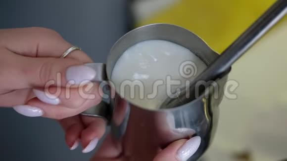 咖啡师用热气腾腾的鞭子抽牛奶女人在咖啡馆做卡布奇诺视频的预览图