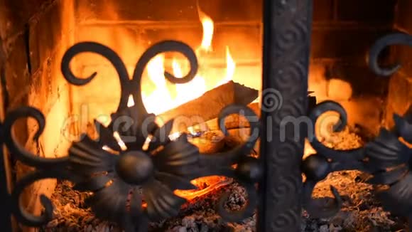 木制原木燃烧着橙色的火焰在带铁门的砖砌壁炉里发光家中温暖壁炉带视频的预览图