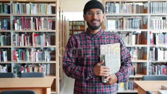 快乐的非裔美国成年学生在图书馆拿书的缓慢动作视频的预览图