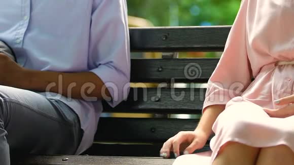 混合种族的男性抚摸着坐在公园长凳上的漂亮女孩子的手调情视频的预览图