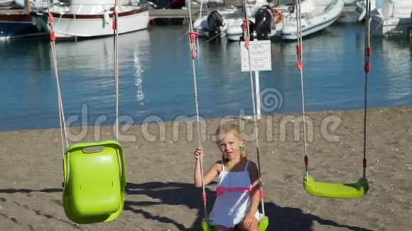 意大利海滩上的小女孩秋千视频的预览图