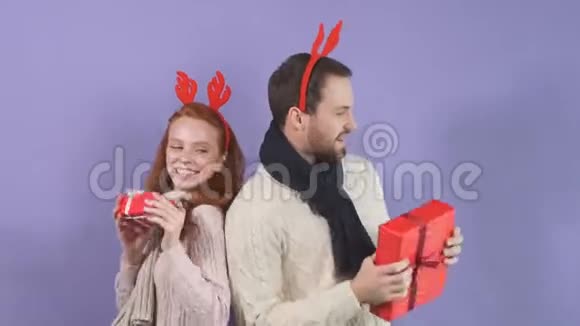 快乐的已婚夫妇穿着白色毛衣玩得很开心还带着圣诞礼物跳舞视频的预览图