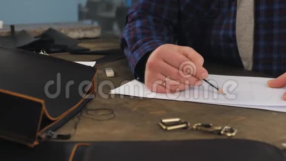 手工制革机是在生产前绘制产品草图在车间生产皮革制品视频的预览图