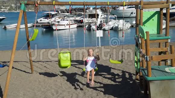 意大利海滩上的小女孩秋千视频的预览图