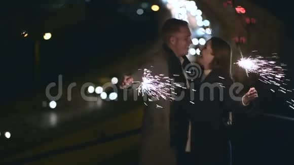 快乐的一对夫妇互相看着拥抱手里拿着火花视频的预览图