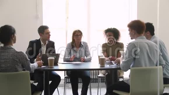 严肃成熟的女企业家在不同的小组谈判中交谈视频的预览图
