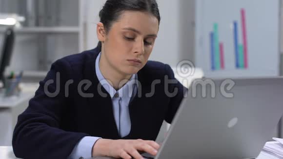 无聊的年轻女人打字笔记本电脑坐桌办公室工作常规疲倦视频的预览图