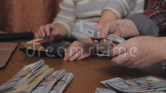 一个年迈的家庭数着坐在房子桌子旁的现金储蓄视频的预览图