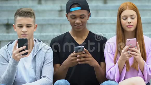 朋友们在户外电话上聊天社交网络快乐的青少年分享新闻视频的预览图