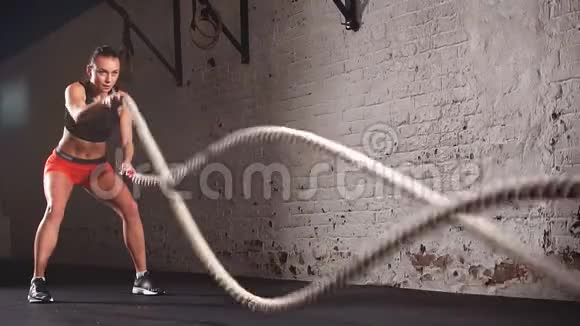 有魅力的年轻健身女运动员在功能训练健身房工作用战绳做运动视频的预览图