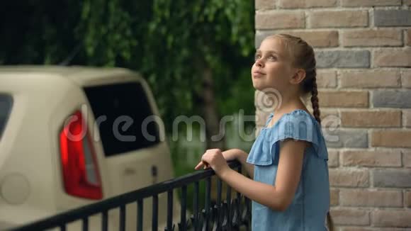 快乐的女孩享受雨天站在农舍后院有趣视频的预览图