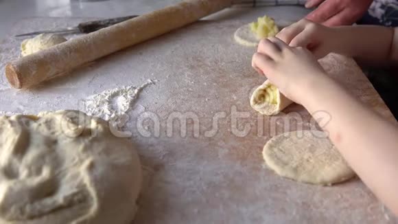 一个小孙女帮助她祖母用土豆馅雕刻馅饼视频的预览图