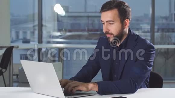 帅哥在用笔记本电脑看监控屏幕视频的预览图