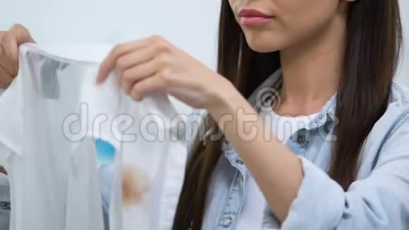 不高兴的年轻女人看着衬衫上的咖啡污渍无效的去斑剂视频的预览图