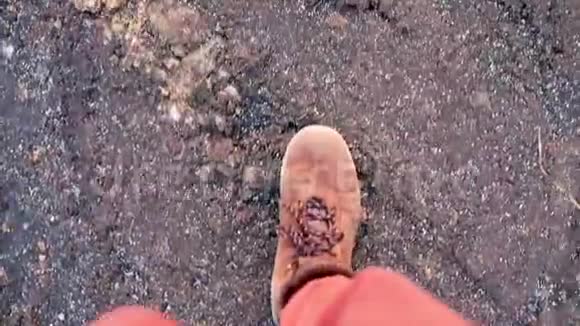 一个穿靴子的游客在旅途中在薄冰上奔跑视频的预览图