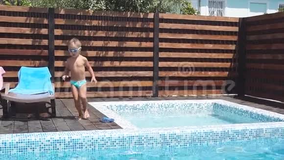 欢快的两个兄弟跳入池中慢动作一家人在室内游泳池里度假视频的预览图