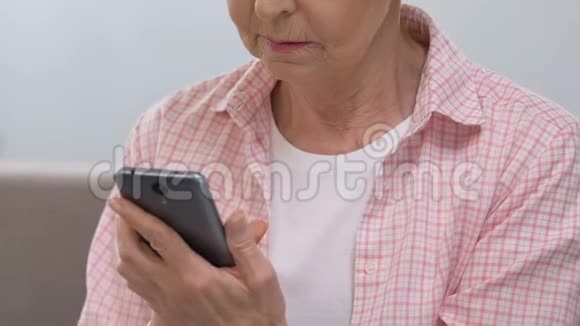 悲伤的老年妇女在智能手机上打字按摩在线咨询医生视频的预览图