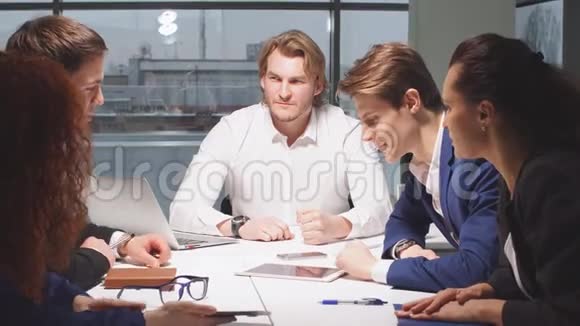 商业公司的年轻办公室员工共用一张桌子视频的预览图