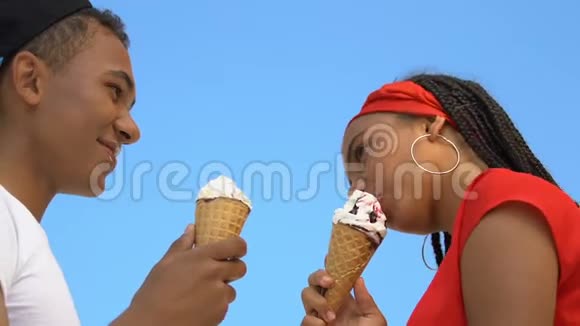 黑人青少年夫妇享受冰淇淋男孩擦女朋友肮脏的鼻子爱视频的预览图