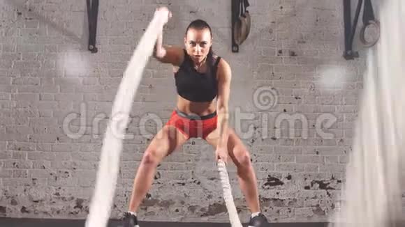 战斗绳索训练有魅力的年轻健身女运动员在功能训练健身房锻炼和战斗视频的预览图
