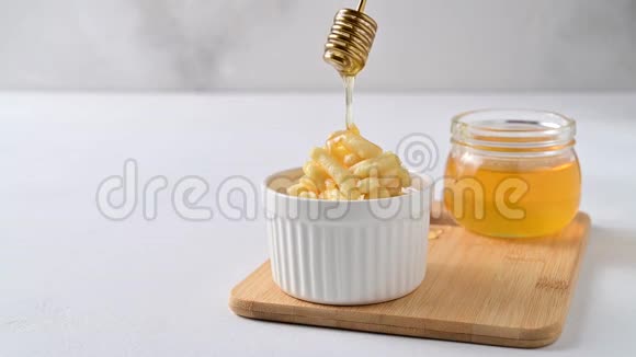 蜂蜜正从一个蜜盘中倒入一个卡盘视频的预览图