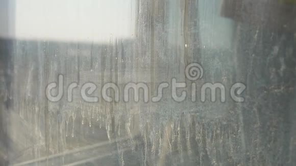 特写女性洗窗喷洒清洁剂用抹布擦拭窗户视频的预览图