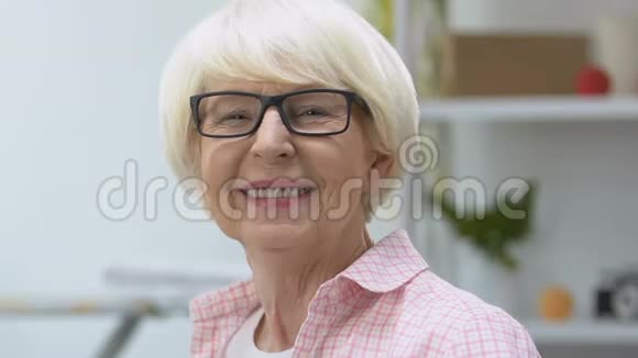 微笑着戴眼镜的老妇人看着相机视力治疗医疗保健视频的预览图
