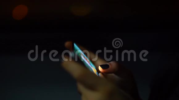 在城市交通公交车上女子的双手在夜间表演智能手机视频的预览图