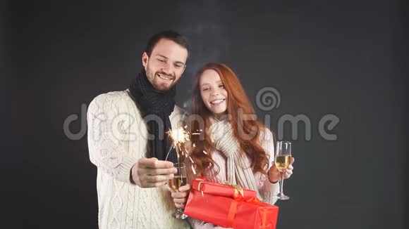 幸福的年轻家庭拿着香槟酒杯和火花庆祝新年视频的预览图