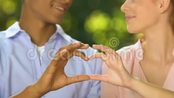 快乐的青少年夫妇用手指唱歌真爱和关系视频的预览图