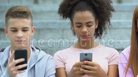 白人和混血青少年滚动智能手机小玩意成瘾的概念视频的预览图