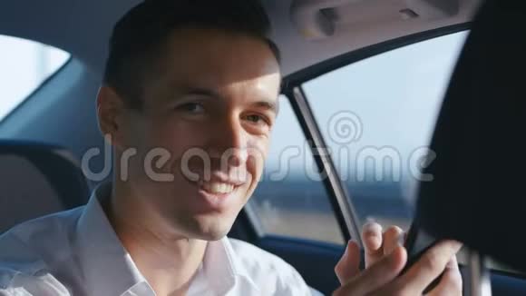 特写商人与司机乘汽车旅行的肖像微笑着穿着白衬衫的年轻人乘出租车视频的预览图