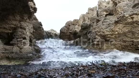海浪溅落在蓝色泻湖峡谷的岩石上视频的预览图