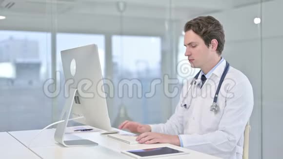 聚焦年轻男性医生在桌面上工作视频的预览图