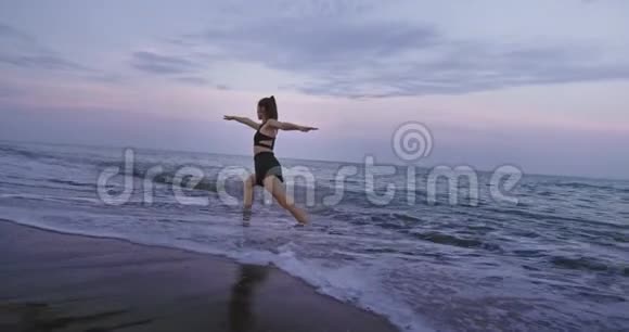 海景美丽的女士做瑜伽姿势伸展身体站在海边的水上慢慢慢慢视频的预览图