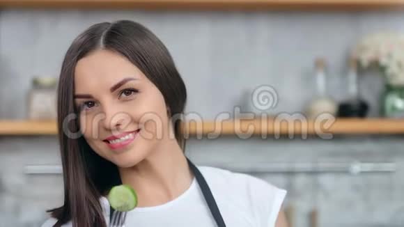 用叉子摆姿势看摄像机拍摄的跳舞微笑女人拿黄瓜的特写镜头视频的预览图