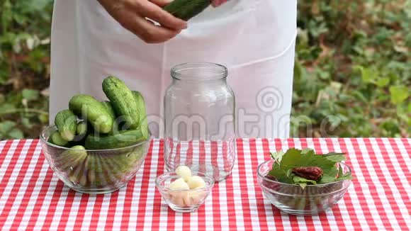女厨师把黄瓜放在空罐子里保存视频的预览图