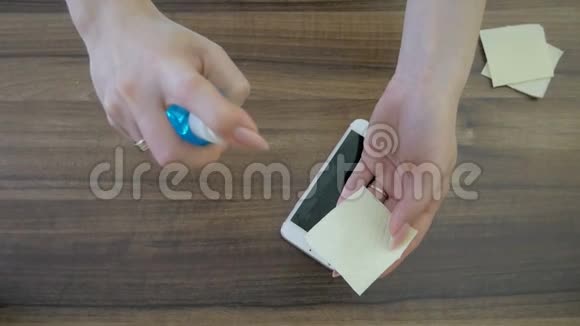 女士用消毒剂清洗智能手机屏幕视频的预览图