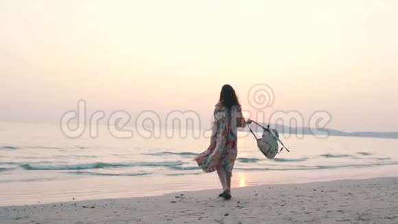 日落时分女孩在海滩上散步视频的预览图