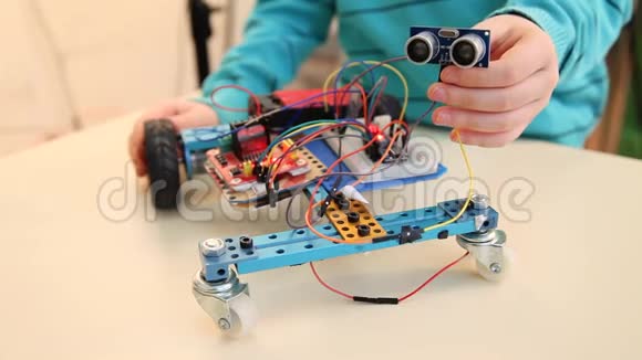 STEM概念男孩调整他的机器人学习编码学习程序视频的预览图