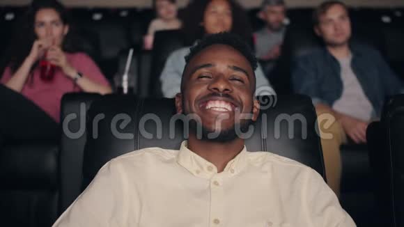 快乐的非裔美国人在电影院里笑看滑稽喜剧视频的预览图