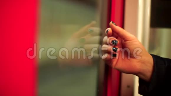 地铁列车车门玻璃上戴着深色指甲的女孩手视频的预览图