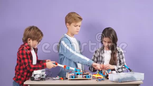 聪明的白种人儿童玩和组装未来主义玩具孤立在工作室与紫色背景视频的预览图
