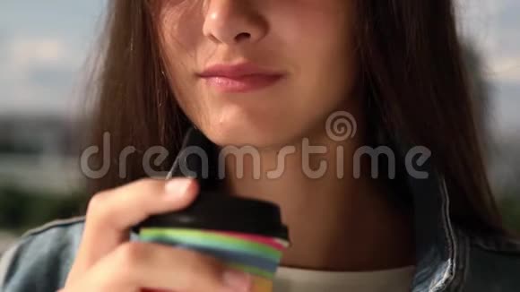 女孩用黑色塑料盖从纸杯里喝咖啡视频的预览图