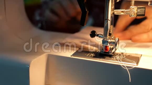 裁剪工艺女性手使用缝纫机与内置灯的光这将是纺织服装视频的预览图