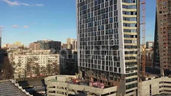 市中心未完工的摩天大楼摄像机沿着摩天大楼从下到上移动视频的预览图