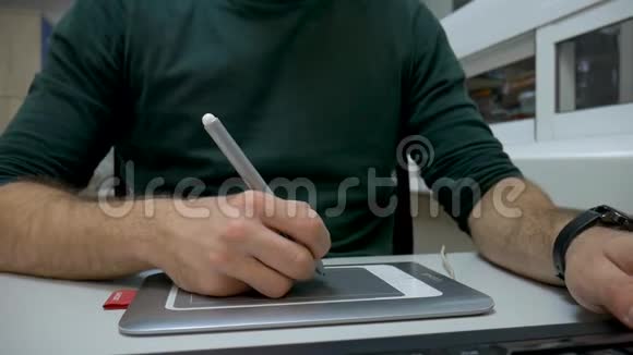 关闭一个平面设计师在平板电脑上素描的视频在办公室工作他用的是智能手表视频的预览图