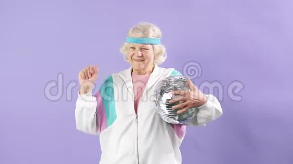 喜笑颜开的老年女子画像身着运动服手持镜球视频的预览图