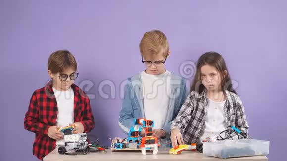 高加索儿童在紫色背景下组装机器人的创造性团队合作视频的预览图